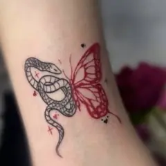 Tatuaż motyl znaczenie: wąż i motyl, symbolizujące przemianę i dualizm.