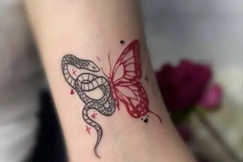 Tatuaż motyl znaczenie: wąż i motyl, symbolizujące przemianę i dualizm.